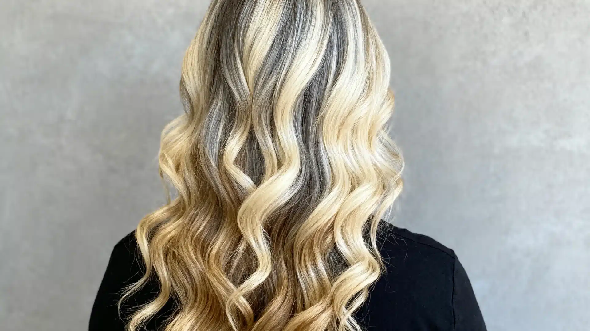 Mid-back view of wavy hair with bold chunky highlights creating high contrast and defined color sections