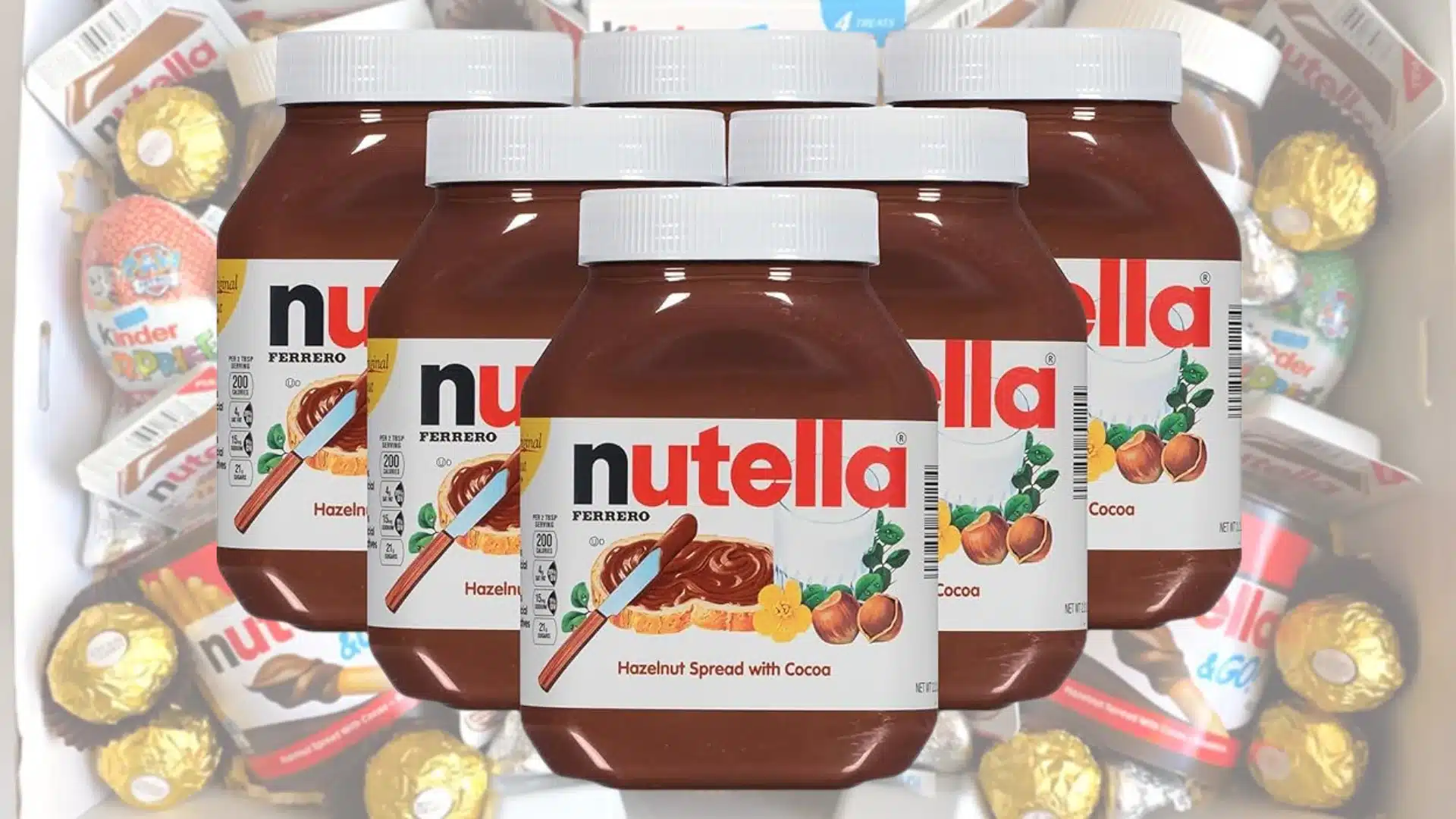 Five large jars of Nutella hazelnut spread with a white lid are prominently displayed against a background filled with assorted Ferrero candies