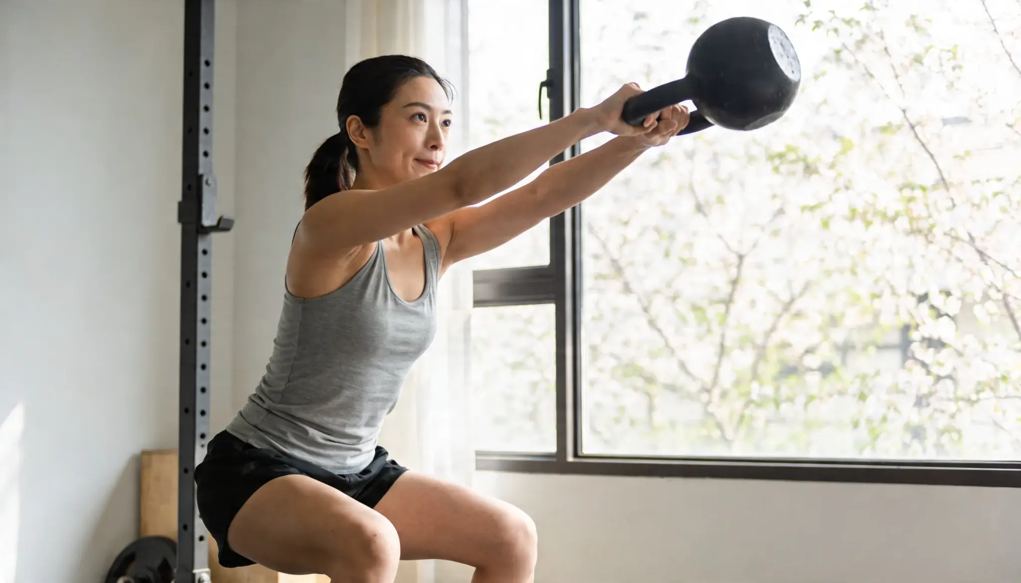 Individual doing functional training movements like squats and kettlebell swings