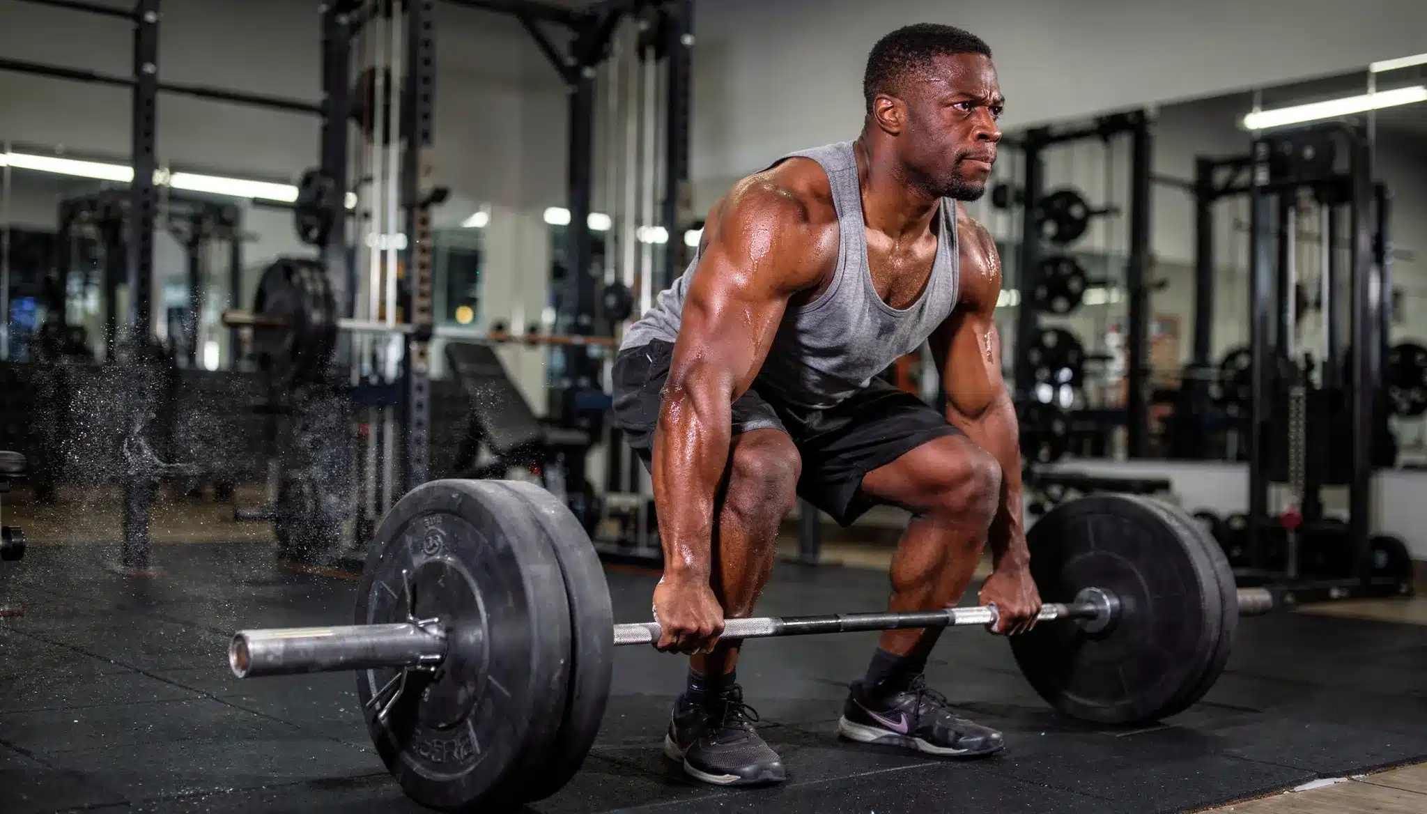 Person performing CrossFit workout with barbell in a high intensity gym setting