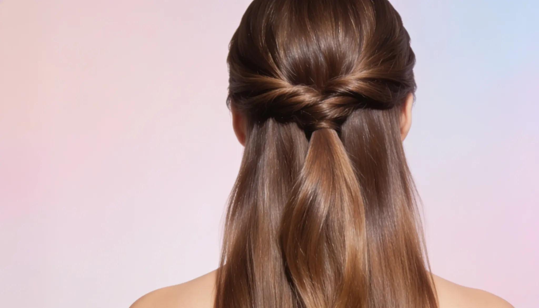 Back view of long brown hair in a relaxed half-up hairstyle with a twisted top section and loose hair flowing down the back.