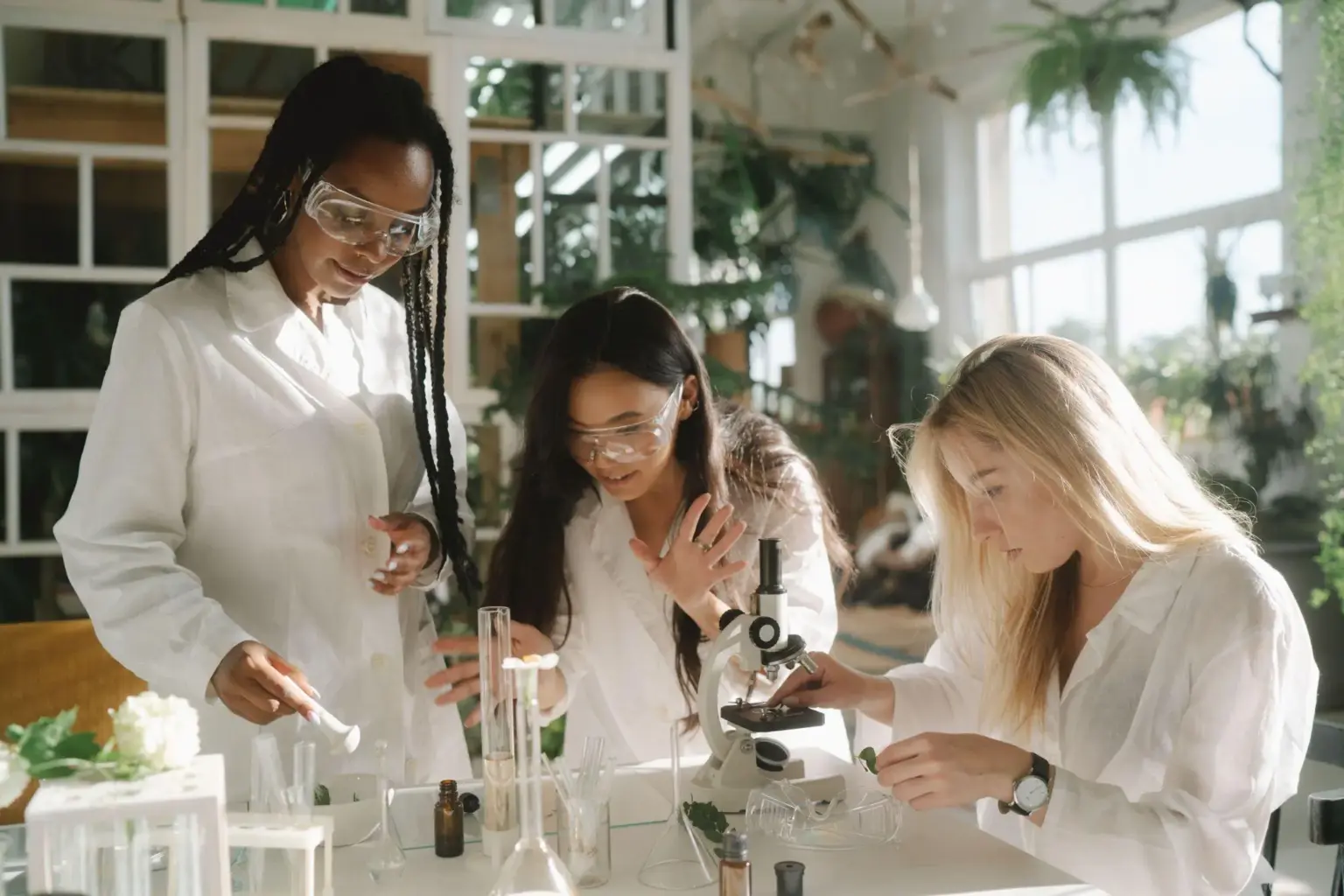 Scientists in lab coats experimenting with microscope and test tubes in a sunlit laboratory setup