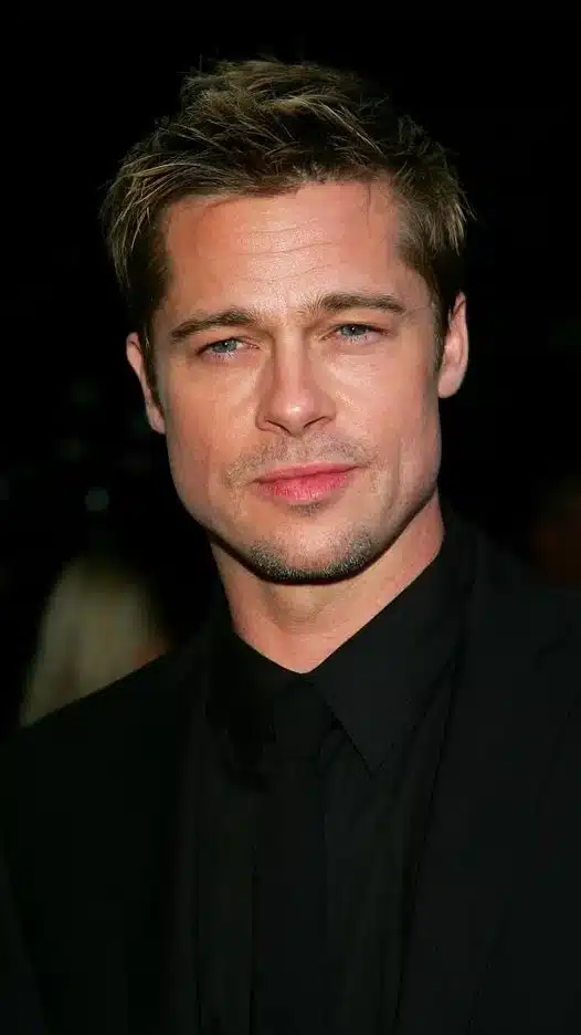 Brad Pitt attending the film premiere, dressed in a stylish suit, smiling at the camera on the red carpet.