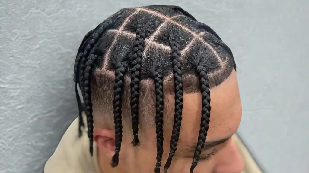 Close-up of a man featuring box braids, highlighting a popular hairstyle choice.