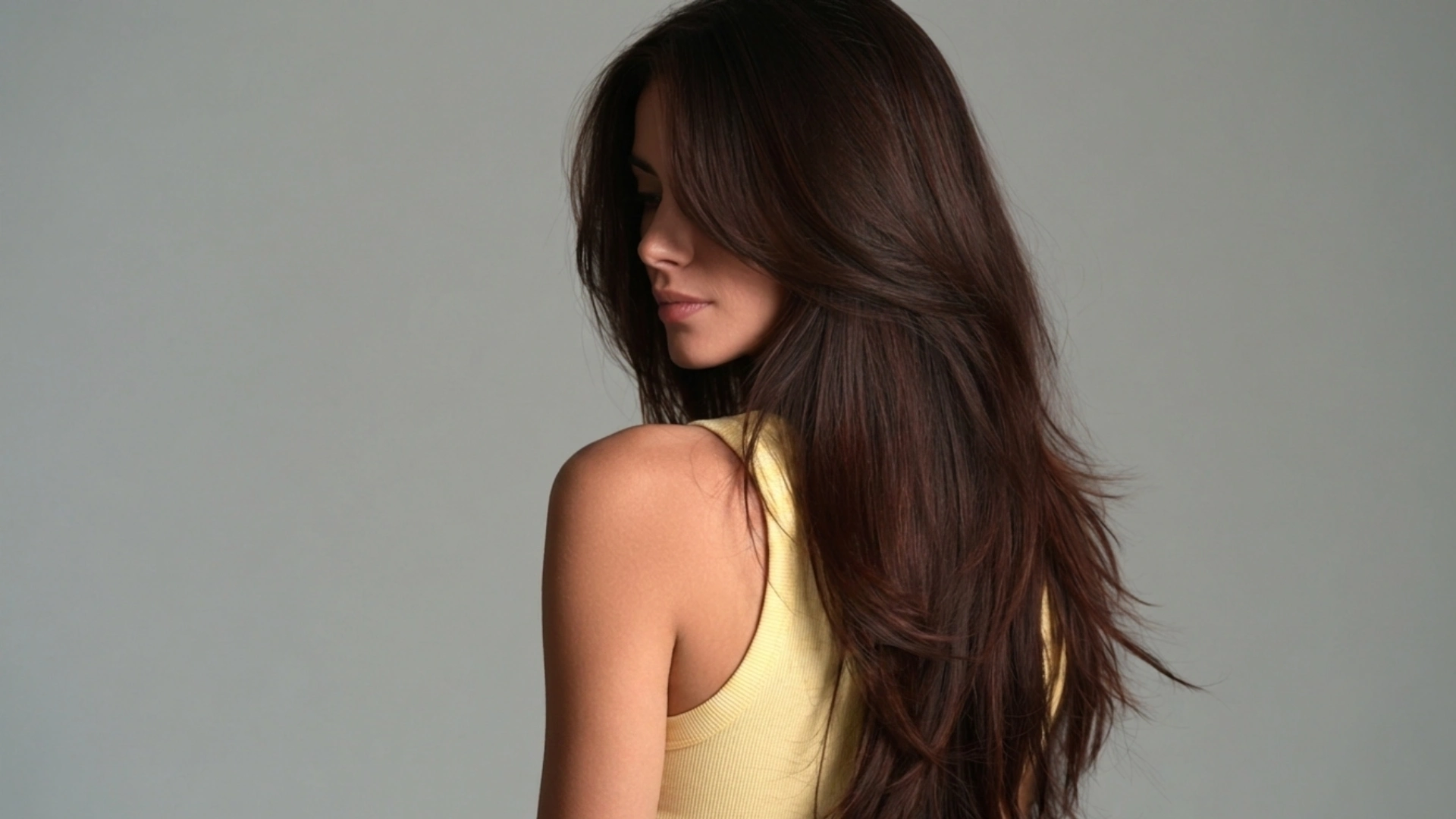 Long, dark hair of a woman featuring stylish razored point cut layers for added dimension and movement.