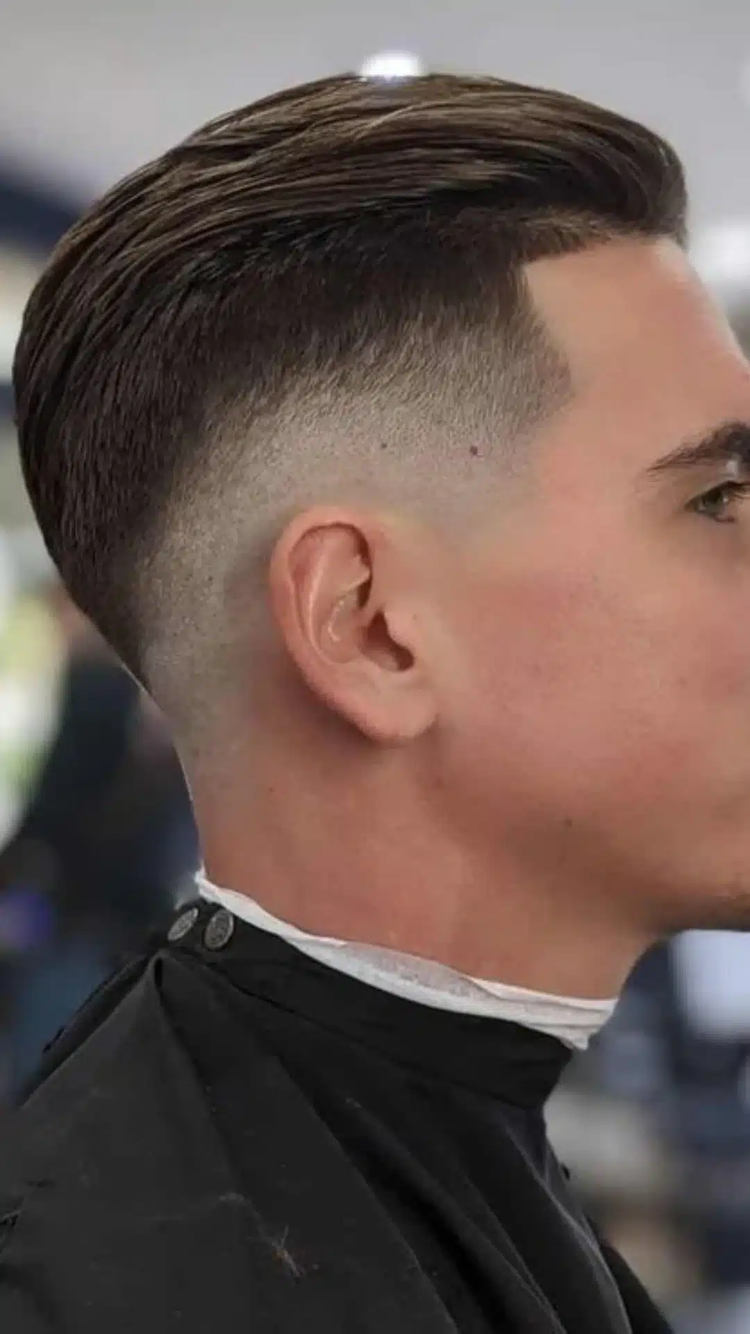 Man with a slick back hairstyle and skin fade that gives square face shapes a clean polished appearance