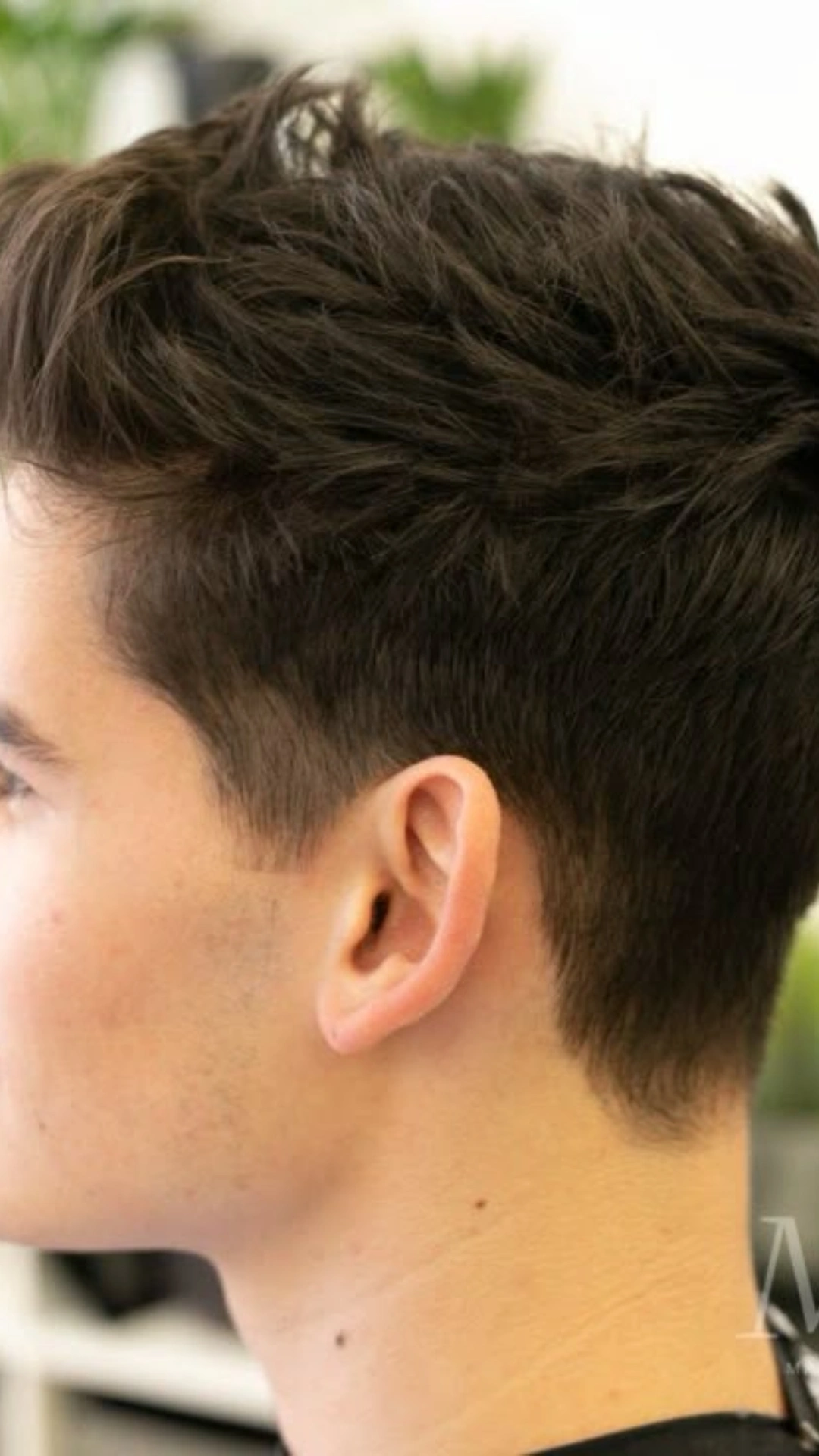 Textured quiff with high fade on dark hair